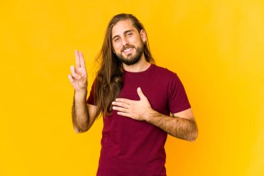 Uzun saçlı genç adam yemin ediyor, elini göğsüne koyuyor..