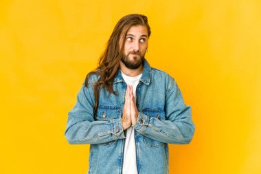 Uzun saçlı genç adam dua ediyor, bağlılık gösteriyor, dindar biri ilahi ilhamı arıyor..