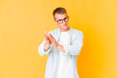 Genç beyaz yakışıklı adam enerjik ve rahat hissediyor, ellerini ovuşturuyor kendinden emin..