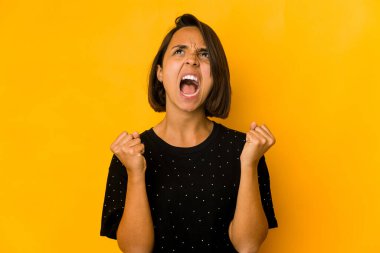 Genç İspanyol kadın sarı yumrukla izole edilmiş zafer kazandıktan sonra, kazanan konsept.