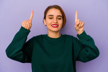 Genç Arap melez kadın iki elini de havaya kaldırarak boş bir alan gösteriyor..