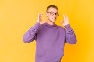 Genç, beyaz, yakışıklı, neşeli ve kendinden emin bir adam iyi bir jest yapıyor..