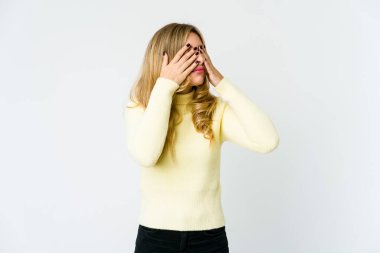 Sarışın, genç bir kadın elleriyle gözlerini kapatmaktan korkuyor..