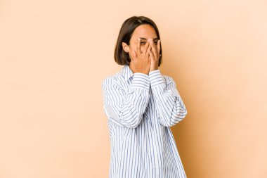 Genç İspanyol kadın kameraya parmaklarıyla göz kırpıyor, utanarak yüzünü kapatıyor..