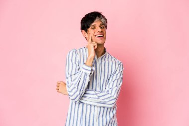 Genç, sıska, gülümseyen, mutlu ve kendinden emin, çenesine elleriyle dokunan bir İspanyol..