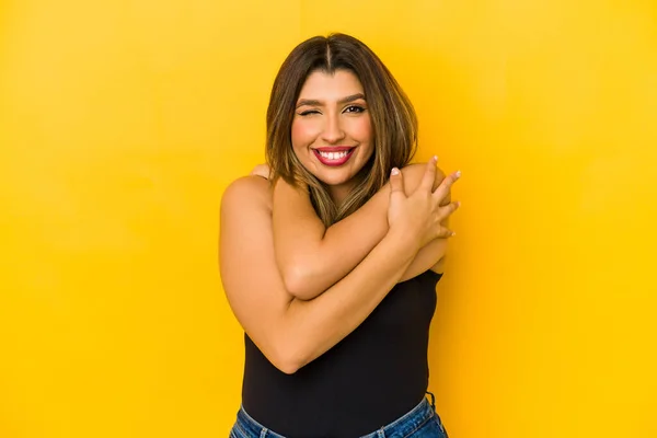 Young Indian Woman Isolated Yellow Background Hugs Smiling Carefree Happy — Stock Photo, Image