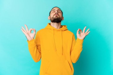 Uzun saçlı genç adam yorucu bir günün ardından rahatlıyor. Yoga yapıyor..