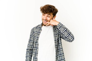 Beyaz arka planda genç bir Arap, parmakları olan bir cep telefonu hareketi gösteriyor..