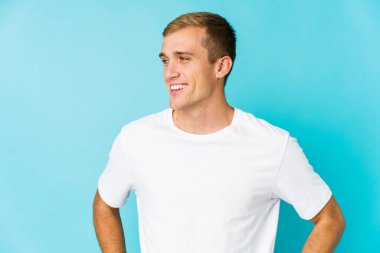 Beyaz tenli yakışıklı, kendine güveni tam. Ellerini kalçasından ayırmıyor..