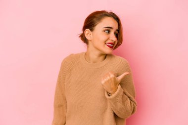 Genç Arap melez kadın başparmağıyla işaret ediyor, gülüyor ve kaygısız..