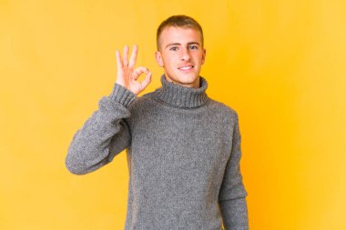 Genç, beyaz, yakışıklı, neşeli ve kendinden emin bir adam iyi bir jest yapıyor..