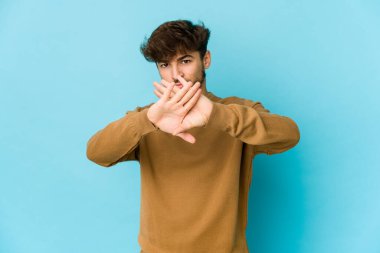 Mavi arka planda genç bir Arap inkâr jesti yapıyor.