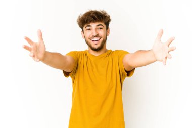 Beyaz arka plandaki genç Arap bir zaferi ya da başarıyı kutluyor. Şaşırdı ve şok oldu..