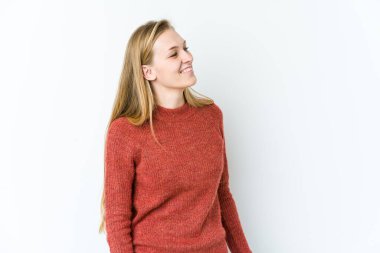 Beyaz arka planda izole edilmiş genç sarışın kadın. Rahatlamış ve mutlu bir şekilde gülüyor. Boynunda dişler var..