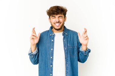 Beyaz arka planda genç bir Arap şans diliyor.