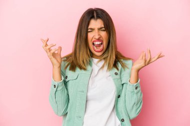 Pembe arka planda izole edilmiş genç Hintli kadın öfkeyle bağırıyor..