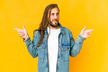 Uzun saçlı genç adam farklı fotokopi alanlarını işaret ediyor, birini seçiyor, parmaklarıyla gösteriyor..