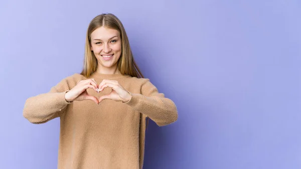 Jovem Loira Isolada Fundo Roxo Sorrindo Mostrando Uma Forma Coração — Fotografia de Stock