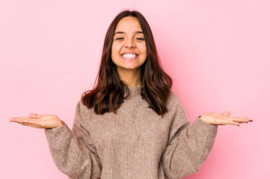 Genç, melez İspanyol bir kadın soyutlanmış, kollarıyla ölçek yapıyor, mutlu ve kendinden emin hissediyor..