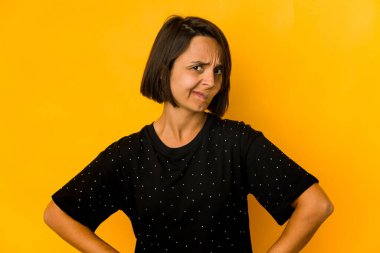 Sarı üzerine izole edilmiş genç İspanyol kadın kafası karışmış, kuşkulu ve güvensiz hissediyor..