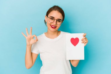 Genç, sıska bir Arap kızın elinde sevgililer günü kartı neşeli ve kendinden emin bir şekilde iyi niyet göstergesi..