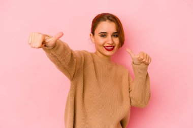 Genç Arap melez kadın iki parmağını da kaldırıyor, gülümsüyor ve kendinden emin..