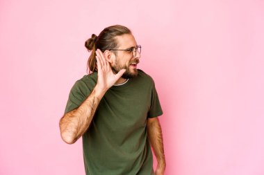 Uzun saçlı genç adam bir dedikoduyu dinlemeye çalışıyor..