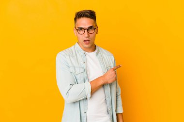 Genç, yakışıklı, beyaz, soyutlanmış, kenarı işaret eden bir adam.