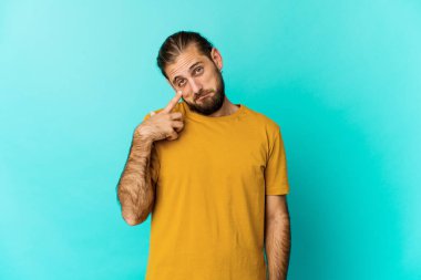 Uzun saçlı genç adam ağlıyor, bir şeyden memnun değil, acı ve kafa karışıklığı konsepti..