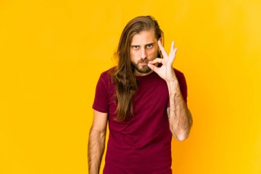 Uzun saçlı genç adam dudaklarında parmaklarıyla bir sır saklıyor..