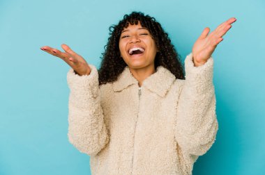 Genç Afrikalı Afro-Amerikan kadın bir zaferi ya da başarıyı kutluyor, şaşırıyor ve şok oluyor..