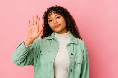 Genç Afro Amerikalı Afro kadın tebessüm ederek 5 numarayı parmaklarıyla gösterdi..