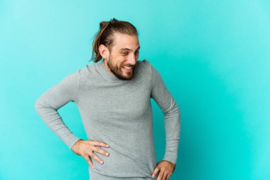 Uzun saçlı genç adam güler, gözlerini kapatır, rahat ve mutlu hisseder..