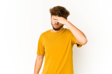 Beyaz arka planda genç bir Arap tapınaklara dokunuyor ve başı ağrıyor..