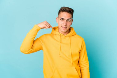 Beyaz tenli yakışıklı bir adam gömlek fotokopi odasını elle gösteriyor, gururlu ve kendinden emin.