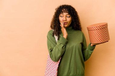 Sevgililer Günü hediyesi tutan Afrikalı Afro-Amerikalı genç bir kadın gizli bir sıcak fren haberi veriyor ve yan bakıyor.