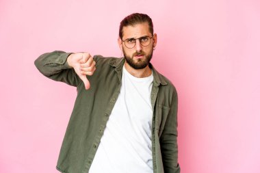 Uzun saçlı genç adam baş parmağını aşağı gösteriyor, hayal kırıklığı konsepti..