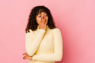 Genç Afrikalı Afro-Amerikan kadın kendini izole etmiş esniyor ve ağzını eliyle kapatan yorgun bir jest yapıyor..