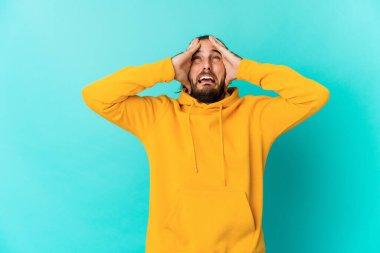 Uzun saçlı genç adam öfkeden bağırıyor..