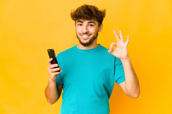 Jovem Indiana Homem Segurando Telefone Alegre Confiante Mostrando Gesto — Fotografia de Stock