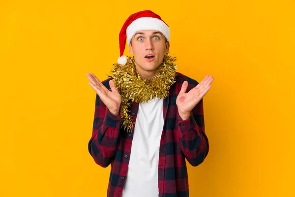 Junge Kaukasische Mann Mit Weihnachtsmütze Hält Ein Geschenk Isoliert Auf — Stockfoto