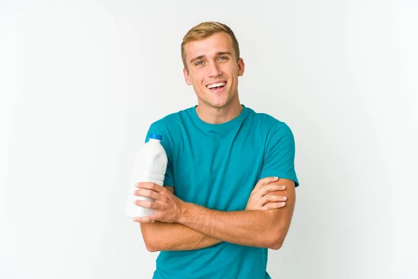 年轻的高加索人喝着白色背景的牛奶 玩得很开心 — 图库照片