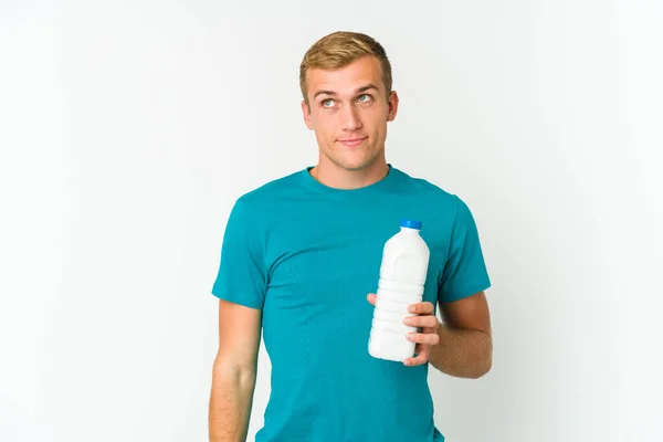 Νεαρός Καυκάσιος Που Πίνει Γάλα Απομονωμένο Λευκό Φόντο Ονειρεύεται Την — Φωτογραφία Αρχείου