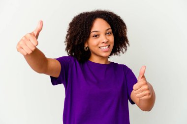 Genç Afro-Amerikan melez kadın kendini soyutlamış iki parmağını kaldırıyor, gülümsüyor ve kendinden emin..