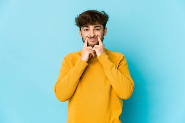 Mavi arka plandaki genç Arap iki seçenek arasında şüphe ediyor.