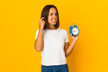 Elleriyle kulaklarını kapatan bir megafon tutan genç İspanyol kadın..