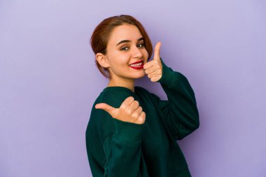 Genç Arap melez kadın iki parmağını da kaldırıyor, gülümsüyor ve kendinden emin..