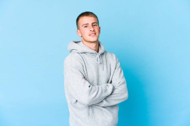 Kendine güveni tam, kararlılığıyla kollarını kavuşturan beyaz tenli yakışıklı bir adam..