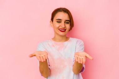 Genç Arap melez kadın elinde avuç içi bir şeyle kameraya sunuyor..