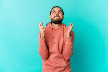 Uzun saçlı genç adam şans diliyor.